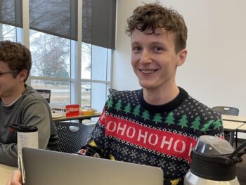 Scott smiling over his computer while he works